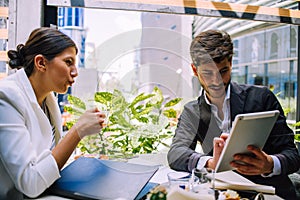 Portrait of two young business colleagues sitting at coffee shop