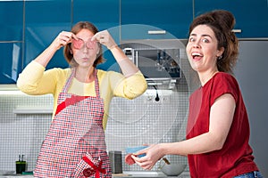 Portrait of two young caucasian women cook in the kitchen and have fun together. Indoors. Concept of joint home cooking for LGBT
