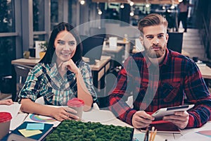 Portrait of two young happy freelancers on financial training, sitting on modern openspace workplace with desktop