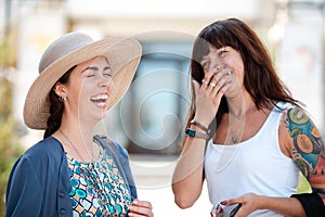 Portrait of two young happy women are laughing merrily in the street. Outdoor. The concept of friendship and psychology