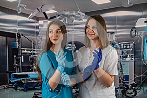 portrait of two young nurses in medical clothes and smiling in the operating room.