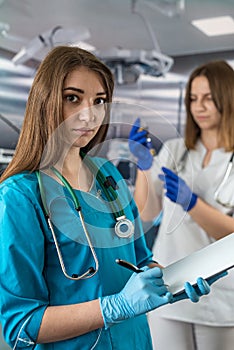 portrait of two young nurses in medical clothes and smiling in the operating room.