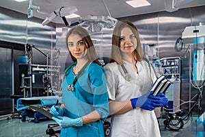 portrait of two young nurses in medical clothes and smiling in the operating room.