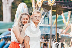 Portrait of two young people walking at the city park posing at the camera. Sensual feelings of in love couples concept image