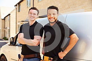 Portrait of two young tradesmen by their van photo