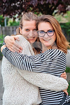 Portrait of two young woman hugging and smiling