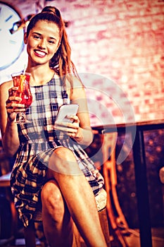 Portrait of two young women having cocktail drinks