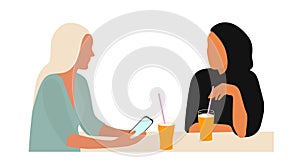 Portrait of two young women talking at table. The concept of friendship or business between people of different cultures