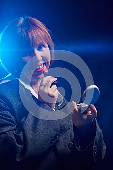 Portrait of an ugly middle-aged woman with red hair, wearing a man`s jacket and red lipstick in the Studio