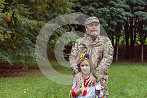 Portrait of a Ukrainian girl in national costume and her military father
