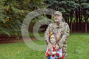 Portrait of a Ukrainian girl in national costume and her military father