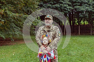 Portrait of a Ukrainian girl in national costume and her military father