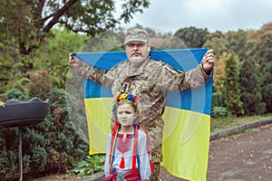 Portrait of a Ukrainian soldier with his little daughter