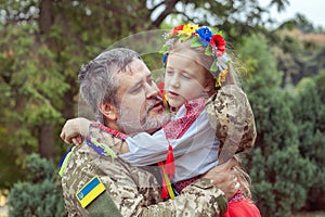 Portrait of a Ukrainian soldier with his little daughter