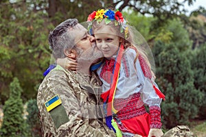 Portrait of a Ukrainian soldier with his little daughter