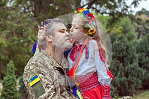 Portrait of a Ukrainian soldier with his little daughter