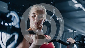 Portrait of an Uncompromising Young Woman Training with Heavy Barbell Exercise in a Dark Gym. A
