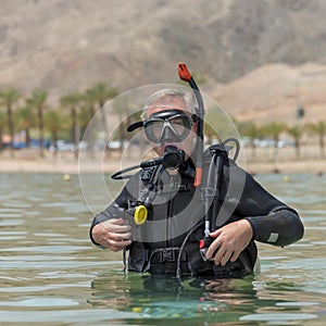 Portrait of underwater diver in basic equipment dives before deep diving. Lessons of underwater diving. Popular water sport and