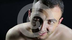 Portrait of undressed guy, black background