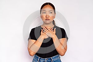 Portrait of uneasy young woman touching her chest photo