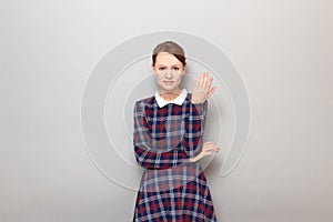 Portrait of unhappy bewildered young blond woman raising one hand