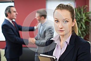 Portrait Of Unhappy Businesswoman With Male Colleague Being Cong