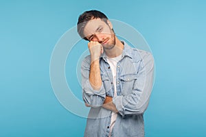 Portrait of unhappy depressed man feeling bored with tedious conversation, looking at camera with disinterest