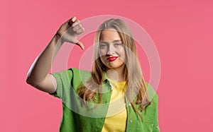 Pretty woman with sign of dislike. Young millennial girl showing thumbs-down photo