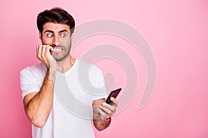 Portrait of unhappy scared middle eastern man indian addicted guy use hold cellphone get failure mistake dislike blog