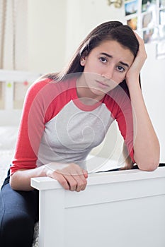 Portrait Of Stressed Teenage Girl In Bedroom