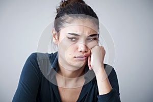 Portrait of unhappy woman on gray background