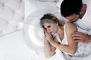 Portrait of unhappy young couple in bedroom