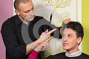 Portrait of unhappy young male at the hairdressing salon