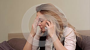 Portrait of unhappy young woman making annoyed phone call at home photo