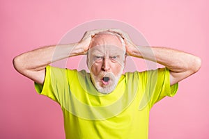 Portrait of unsatisfied aged guy hands on head open mouth yell loud lime clothing  on pink color background