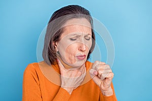Portrait of unsatisfied aged lady arm touch neck coughing in fist feel bad isolated on blue color background