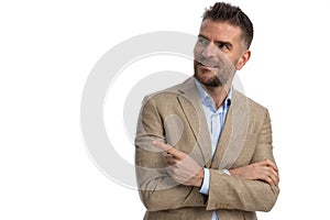Portrait of unshaved businessman looking and pointing finger to side