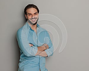 portrait of unshaved casual guy smiling and crossing arms