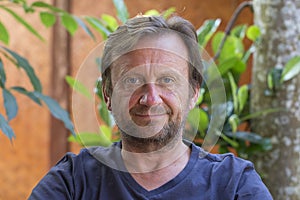 Portrait of an unshaven middle-aged man relaxing on the nature in summer day