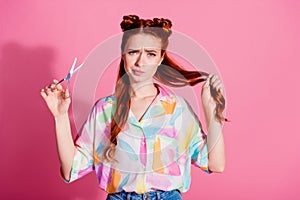 Portrait of unsure nice woman wear print shirt hand hold foxy hair scissors think to make tail shorter isolated on pink