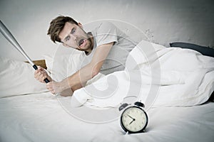 Portrait upset angry with baseball hit young man screaming at alarm clock