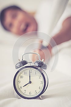 Portrait upset angry with baseball hit young man screaming at alarm clock on bedroom.