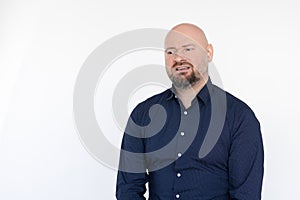 Portrait of upset frowning bearded handsome middle-aged man in blue shirt sitting, looking aside on white background.