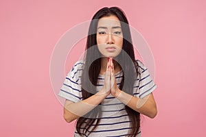 Portrait of upset girl with long hair in striped t-shirt sincere saying please with imploring eyes