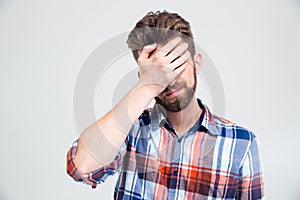 Portrait of upset man covering his face with hand