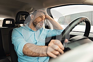 Upset bored man driving new car in city