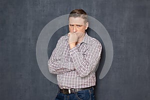 Portrait of upset man touching chin with hand