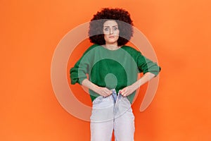 Portrait of upset sad young adult woman with Afro hairstyle wearing green casual style sweater