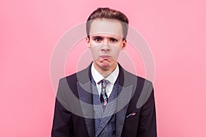 Portrait of upset stressed out businessman is about to cry, hopeless sadness expression. indoor studio shot isolated on pink