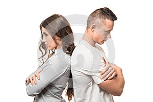 Portrait of upset unhappy couple standing back to back holding arms crossed ignoring each other isolated on white